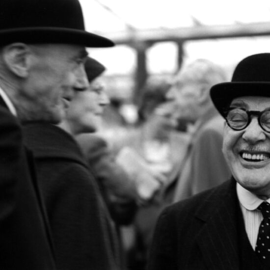 Two elderly men in bowler hats share a joke inside a marquee at the Chelsea Flower show in 1962
