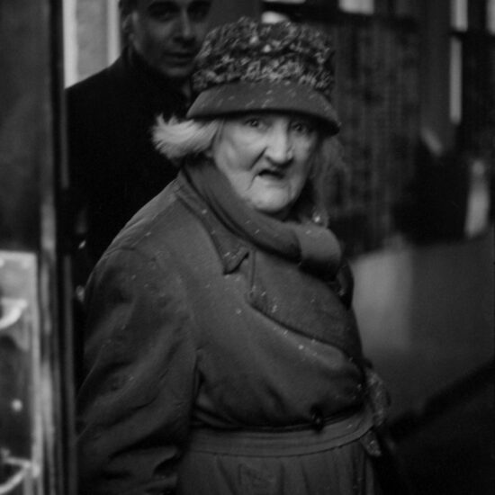 An elderly woman with snowflakes on her coat is photographed during a housing demonstration in Westmoreland Road, Southwark, during the freezing winter of 1963