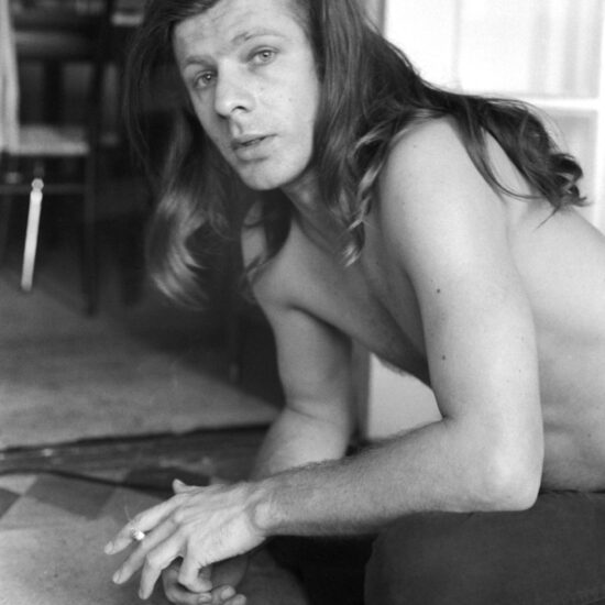 Peter Orlovsky sits cross-legged on the floor of the apartment he shares with Allen Ginsberg, New York, 1965