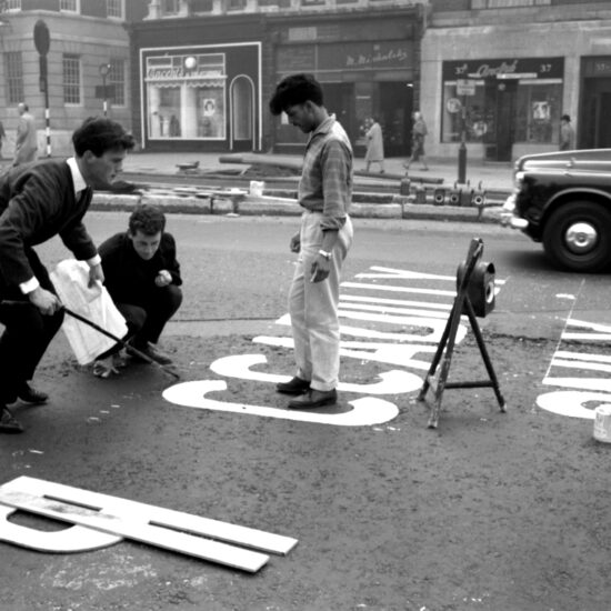 On the opening day of the Hyde Park Corner underpass three young men stand in the middle of the road as they measure out the gaps between letters before they paint filtering instructions onto the tarmac. They have yet to chalk out the letters P and I in the directive PICCADILLY ONLY: the rest has already been painted onto the road; London, October 17 1962