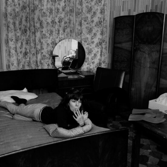 A female sex worker in Notting Hill (Cree), lying on a bed with rubber gloves and tissues in the forground