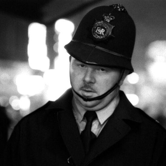 A white male Police Constable with the Metropolitan Police appears exhausted during a demonstration in London, circa 1961. He looks straight at the camera