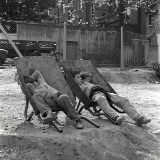 Two young boys sleep in wheelbarrows, Notting Hill, west London, circa 1962